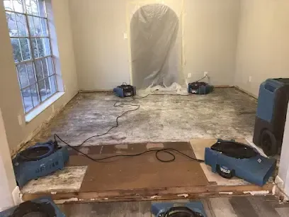 Air movers and a dehumidifier arranged in a room after a water loss