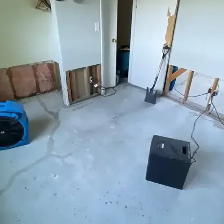 Drying equipment running in a gutted room with bare floor and opened walls