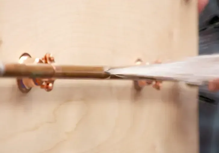 Water spraying out of a split copper supply pipe